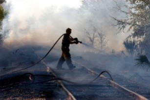 ###Ocala Star-Banner, Grass fire , Silver Springs Shores FL - Contact photographer at 352-598-7976### A Marion County Fire Rescue fire fighter and EMT Cory Parrot(cq) is busy spraying water in the area of the CSX Rail Road, near Bahia Court Way and Bahia Court Track, Thursday afternoon, March 2, 2006, Silver Springs Shores, FL. ( Jannet Walsh/Star-Banner)2006