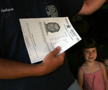 ###Belleview Police visit Sex offenders### Chris Applegate holds a flyer he received from Belleview Police Detective Larry Thompson of a neighbor, sex offender Mark R. Nelson. Right is Applegate's daughter Isis Applegate, Wednesday morning, May 11, 2005, Belleview, FL, USA. (Jannet Walsh/Star-Banner)2005
