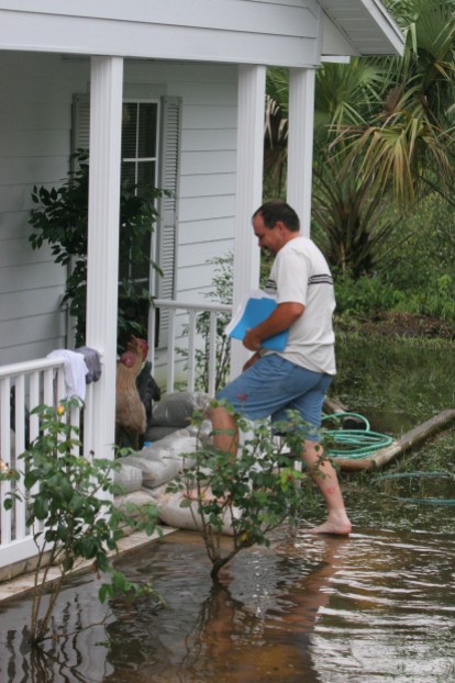 ###NEWS - Silver Springs Shores home located at 6 Peacon Run Harbor is flooded, Silver Springs Shores- CONTACT PHOTOGRAPHER 352-598-7976 - cell### Drew Pearce (cg) with closing papers from house, walks in the water the front steps of his house located at 6 Peacon Run Harbor. Pearce and his wife purchased the home on June 23, 2005, and now are flooded with water covering their property, Thursday evening, July 14, 2005, in Silver Springs Shores, FL. ( Jannet Walsh/Star-Banner)2005