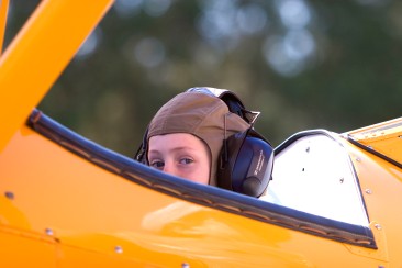 ###Ocala Star-Banner - Camp Fly for kids to learn about flying, Belleview, FL### Andrea Froom(cq) age 7, of Ocala, wearing a pilot's helmet was a passenger of pilot Tim Kirby(cq) flying his Stearman 1941 biplane to demonstrate to students at Camp Wings at at Back Achers Airfield to learn about flying, Saturday morning, Nov. 4, 2006, Belleview, FL. ( Jannet Walsh/Star-Banner)2006